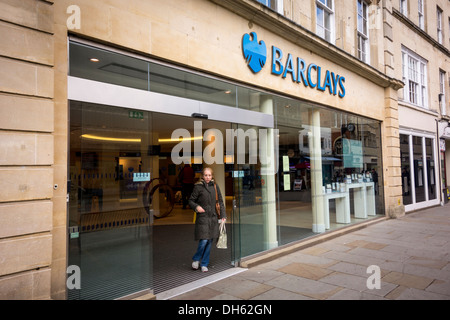 Une femme marche hors de la direction de la Barclays Bank, UK Banque D'Images