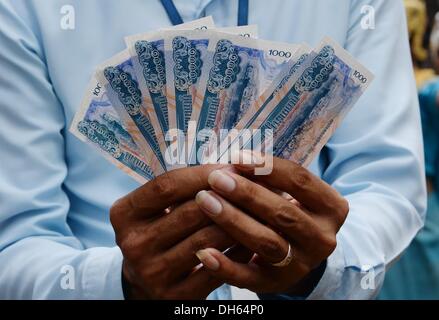 Siem Reap, Cambodge. 13 Oct, 2013. Un homme détient des billets de riels cambodgiens à Siem Reap, Cambodge, 13 octobre 2013. Photo : Jens Kalaene/dpa/Alamy Live News Banque D'Images