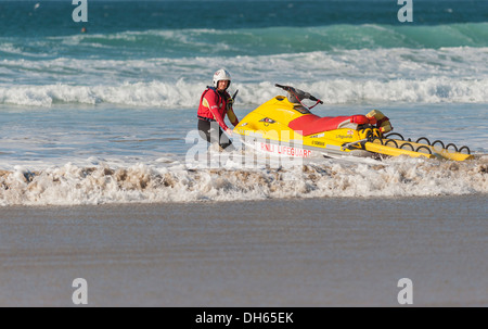 Un sauveteur le lancement d'un scooter à la plage de Fistral. Banque D'Images