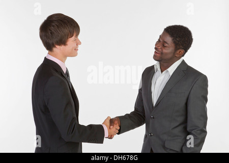 Deux jeunes hommes de différentes races shaking hands Banque D'Images