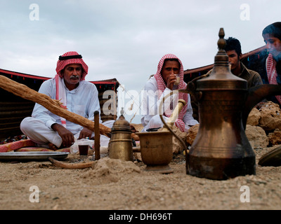 Les bédouins au petit-déjeuner, thé et du pain cuit dans les cendres Gabouri, peuples du désert d'Egypte réunion à Wadi El Gamal, Parc National Banque D'Images