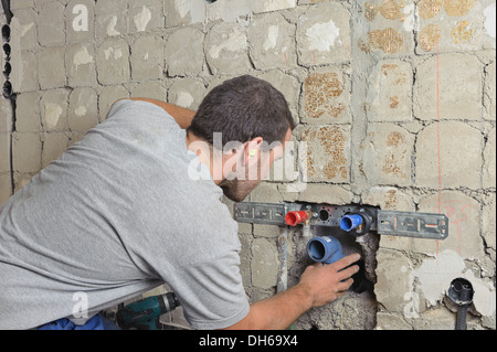 Un électricien, mécanicien de systèmes de génie sanitaire, chauffage et climatisation, installation d'un tuyau d'égout, de remise à neuf Banque D'Images