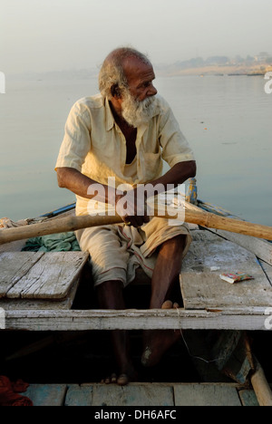 Vieil homme sur un bateau d'aviron le Gange, Sunrise, Varanasi, Inde, Asie Banque D'Images