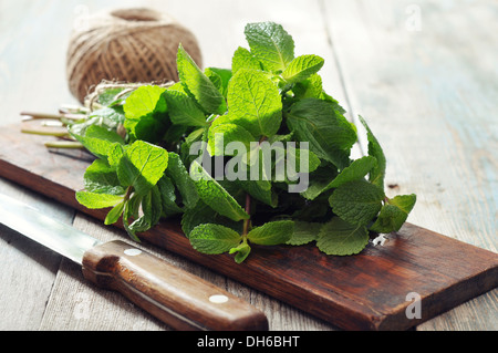 Feuilles de menthe verte avec de la chaux sur fond de bois Banque D'Images