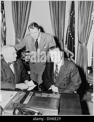 Photographie du Président Truman à son bureau dans le bureau ovale avec le secrétaire de l'intérieur Oscar Chapman et... 200262 Banque D'Images