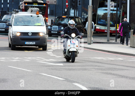 Un motocycliste et autre trafic voyageant le long d'une route à Londres, Angleterre Banque D'Images