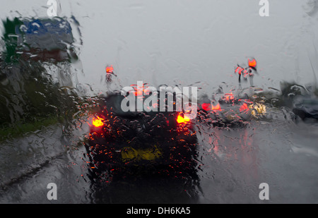 Vue à travers le pare-brise humide avant d'une voiture lors d'une forte pluie battante Banque D'Images