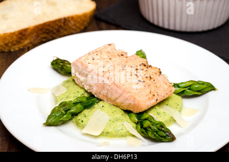 Filet de saumon aux asperges vertes sur une plaque blanche Banque D'Images