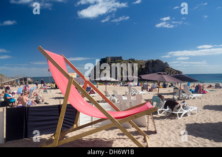 Chaise longue sur la plage château géant Tenby, Pembrokeshire Wales UK les gens sur la plage en été journée ensoleillée Banque D'Images