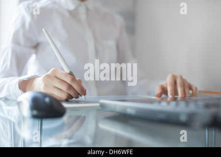 Femme concepteur à l'aide de tampon graphique in office Banque D'Images