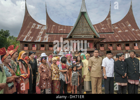 La population locale en costume traditionnel en face d'une grande maison (Rumah Gadang, Solok), à l'Ouest de Sumatra, Indonésie Banque D'Images