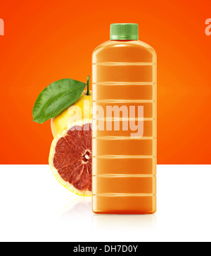 Le jus de pamplemousse dans un contenant de plastique verseuse à orange et feuilles sur un fond blanc. Banque D'Images