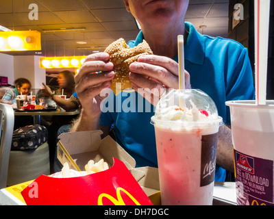 L'homme de manger au restaurant McDonald's , Cheesebuger, frites et Milkshake repas, NYC, USA Banque D'Images