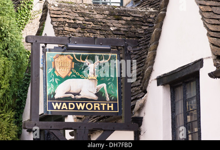 Castle Combe et un joli village historique dans le Wiltshire England UK Le White Hart Wadworth enseigne de pub Banque D'Images