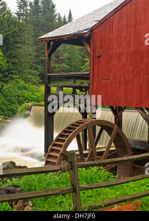 Verse l'eau sur un barrage à côté d'un vieux moulin rouge avec une roue à eau près de la Weston Playhouse de Weston, Vermont Banque D'Images