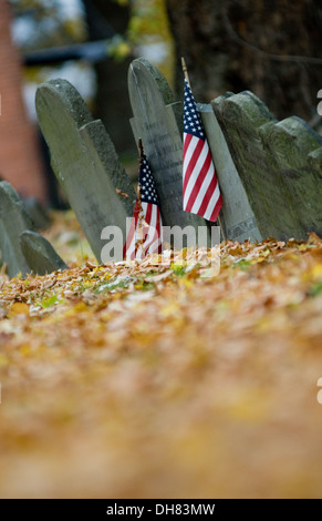 Drapeaux américains ornent les pierres tombales d'anciens combattants de guerre dans un cimetière de l'époque révolutionnaire dans la région de Boston, Massachusetts, en automne. Banque D'Images