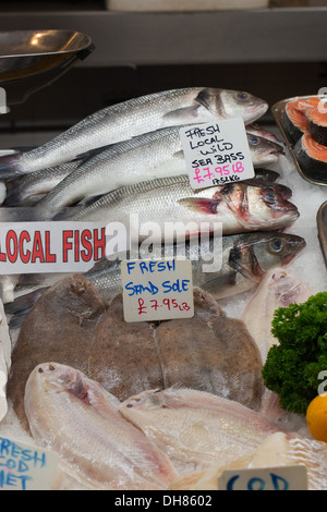 L'étal de poisson Monger de marchandises. Beresford Marché aux poissons. Beresford Street, St Helier, Jersey, Channel Islands. L'Angleterre. Loup de mer au Royaume-Uni Banque D'Images