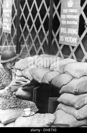 Une jeune femme est assise sur des sacs à l'extérieur de son bureau de Londres pendant le Blitz Banque D'Images