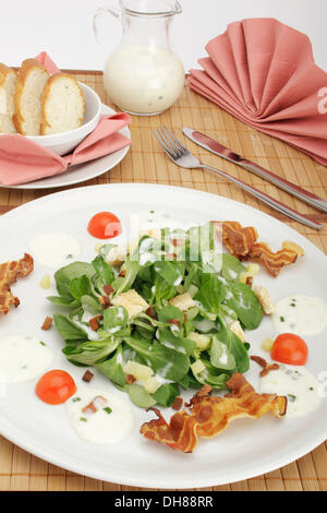 Salade de pommes de terre sur le terrain avec la vinaigrette, croûtons de pain, lard grillé et pain français Banque D'Images