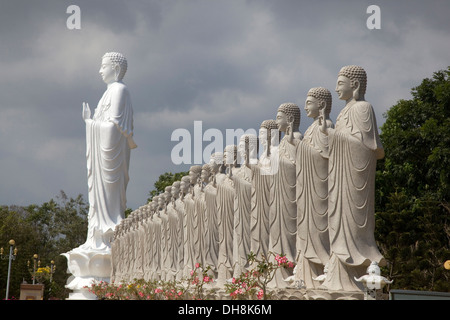 Grand Bouddha Debout avec 48 petits bouddhas debout, dans le cadre de Golden temple bouddhiste, Phu My, Vietnam. Banque D'Images