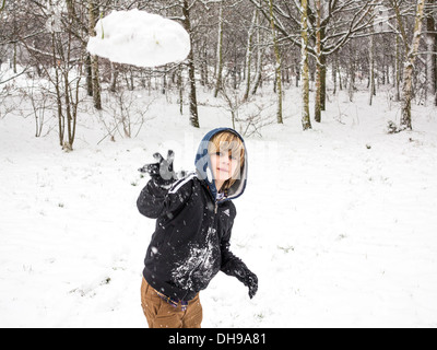 Un garçon jette une boule de neige chez le photographe Banque D'Images