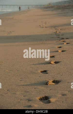 Les empreintes de pas dans le sable projettent de longues ombres à l'aube sur Manhattan Beach en Californie. (ÉTATS-UNIS) Banque D'Images