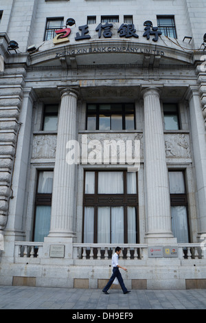 Homme marchant passé Zheng Xin Bank Company Limited sur le Bund, Shanghai Banque D'Images