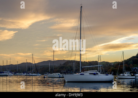 Un coucher de soleil colorés sur scène dans Windermere Lake District. Beaux tons orange dans les nuages et le ciel. Yachts sur un lac. Banque D'Images