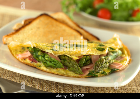 Omelette au jambon et asperges vertes rôties avec du pain et une salade fraîche à l'arrière Banque D'Images