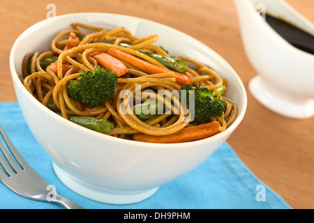 Et Légumes sautés dans spaghetti complet bol blanc avec de la sauce soja dans le dos Banque D'Images