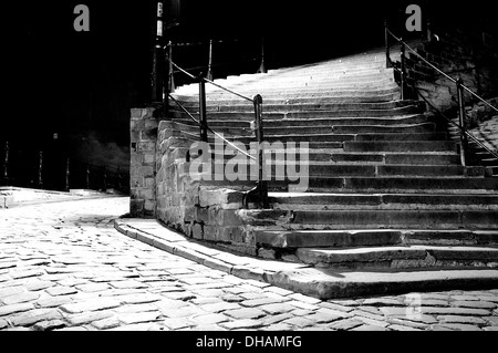 Noir et blanc, low angle shot d'une rue pavée avec un escalier de pierre à droite de l'image. Banque D'Images