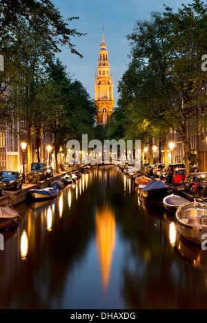 La Zuiderkerk éclairés la nuit et se reflètent dans un canal bordé d'arbres. Amsterdam, Pays-Bas Banque D'Images