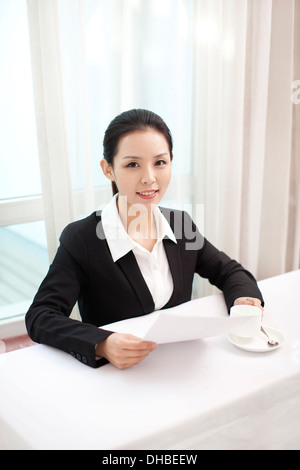 Smiling businesswoman holding papier dans un bureau Banque D'Images