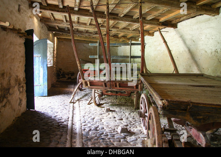 Vieux charrettes en bois dans le hangar à voiturettes de Godolphin House, Helston, Cornwall, Angleterre, Royaume-Uni Banque D'Images