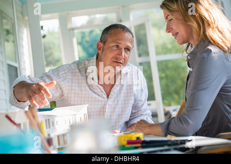 Une cuisine de la ferme. Un modèle d'une maison sur la table. La conception d'une maison. Un couple. Banque D'Images