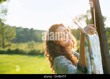 Une femme étendre le linge sur l'étendoir, dans l'air frais. Banque D'Images