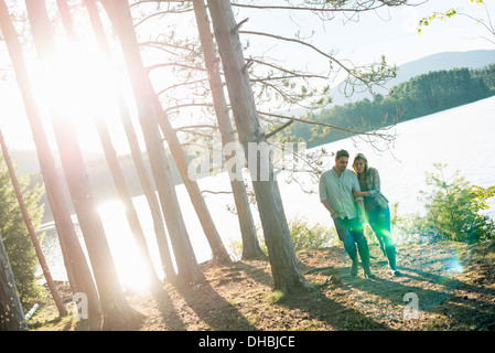 Un couple en train de marcher dans les bois sur les rives d'un lac. Banque D'Images