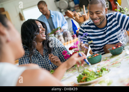 Un groupe de femmes et des hommes à un repas dans une cuisine de la ferme. Banque D'Images