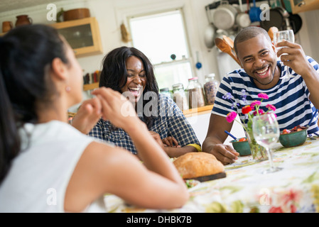 Un groupe de femmes et des hommes à un repas dans une cuisine de la ferme. Banque D'Images