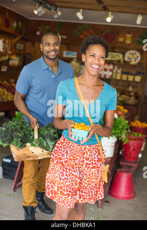 Deux personnes dans un magasin de la ferme, en choisissant des légumes biologiques. Banque D'Images