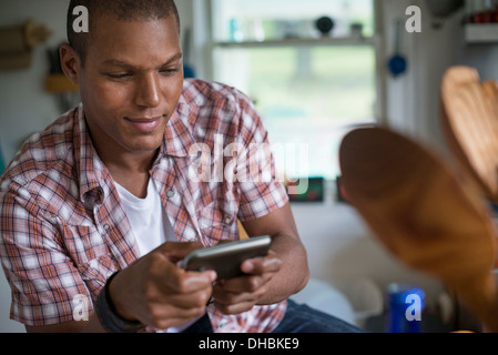 Un homme dans une cuisine, à l'aide d'une tablette numérique. Banque D'Images