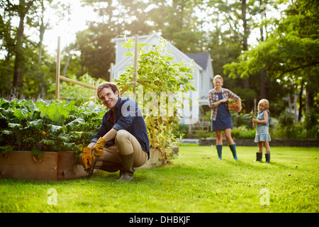 Trois personnes, deux adultes et un enfant dans un jardin potager. Banque D'Images