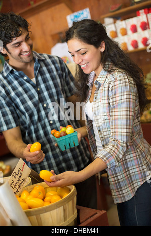 Une ferme la culture et la vente de légumes et fruits biologiques. Un homme et une femme qui travaillent ensemble. Banque D'Images