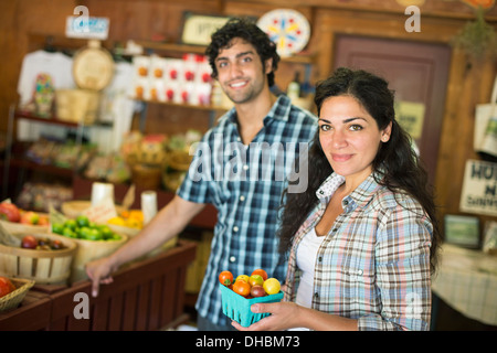 Une ferme la culture et la vente de légumes et fruits biologiques. Un homme et une femme qui travaillent ensemble. Banque D'Images