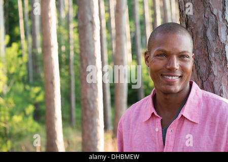 Des arbres sur les rives d'un lac. Un homme souriant à la caméra. Banque D'Images