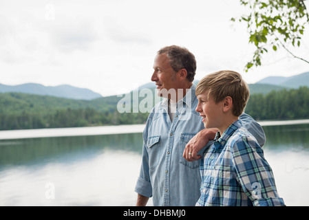 Une famille à l'extérieur sous les arbres sur une rive du lac. Père et fils. Banque D'Images