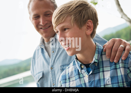 Une famille à l'extérieur sous les arbres sur une rive du lac. Père et fils. Banque D'Images