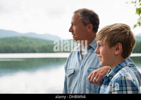 Une famille à l'extérieur sous les arbres sur une rive du lac. Père et fils. Banque D'Images