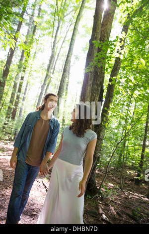 Deux personnes, une jeune femme et l'homme, marchant côte à côte dans les bois. Banque D'Images
