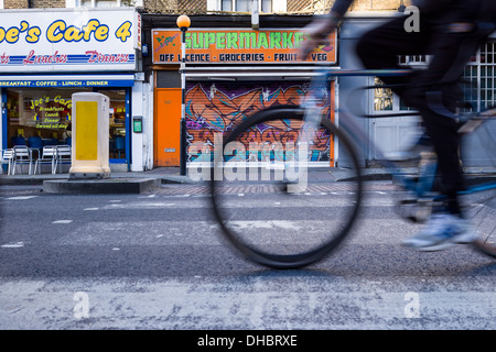 Un cycliste traverse un Pelican Crossing sur la Caledonian Road à Islington au nord de Londres. Banque D'Images